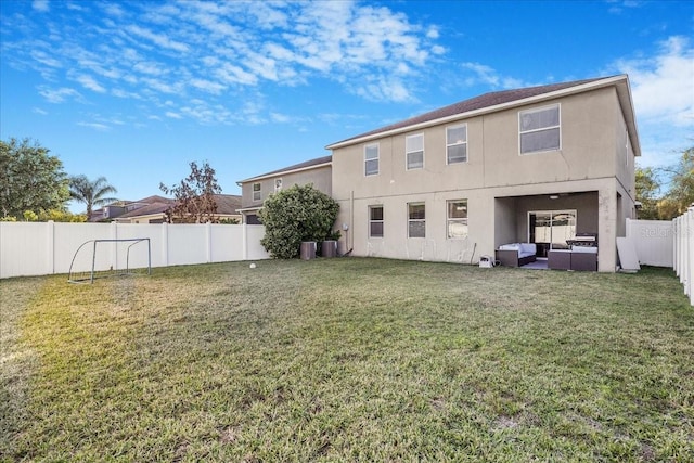 back of property with stucco siding, a lawn, a fenced backyard, and outdoor lounge area