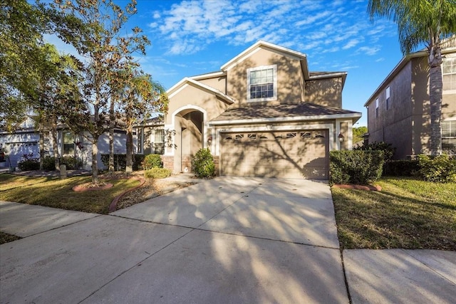 traditional home featuring stucco siding, driveway, and an attached garage