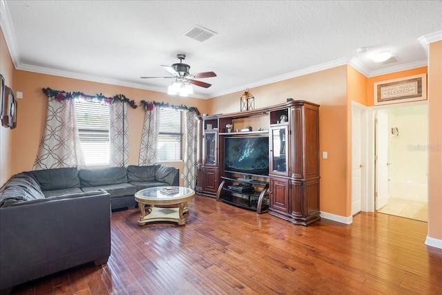 living area featuring visible vents, wood finished floors, a ceiling fan, and ornamental molding