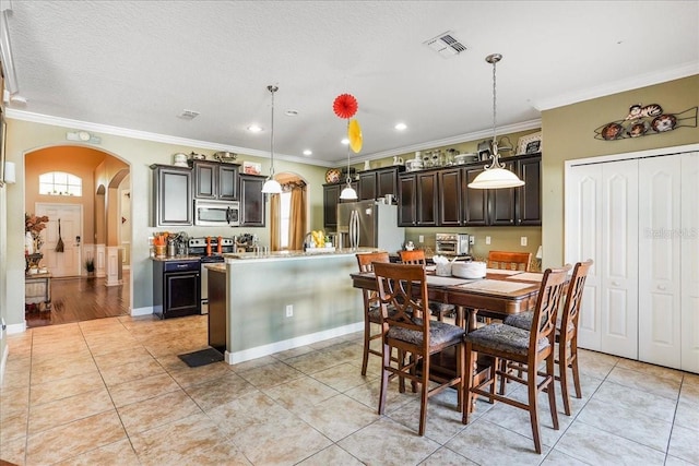 dining room featuring light tile patterned floors, visible vents, arched walkways, and ornamental molding
