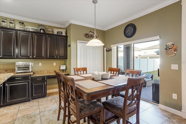 dining room featuring baseboards, ornamental molding, light tile patterned flooring, and a toaster