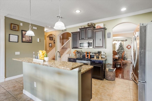 kitchen featuring arched walkways, light stone countertops, stainless steel appliances, and light tile patterned flooring