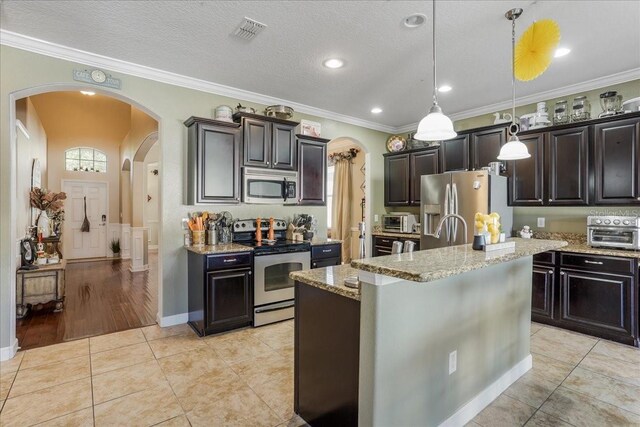 kitchen featuring light tile patterned flooring, visible vents, arched walkways, and appliances with stainless steel finishes