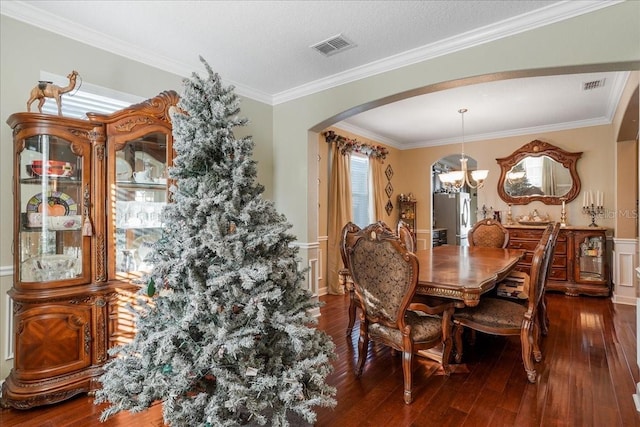 dining room with visible vents, arched walkways, a notable chandelier, and hardwood / wood-style floors