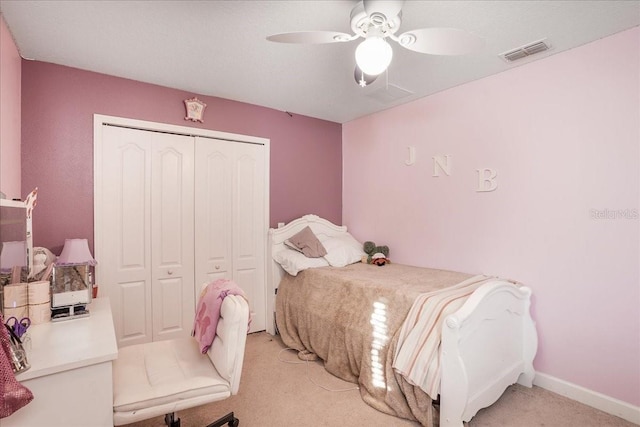 bedroom with visible vents, light carpet, a closet, baseboards, and ceiling fan