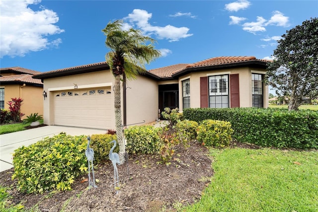 view of front of house featuring a tile roof, a garage, driveway, and stucco siding