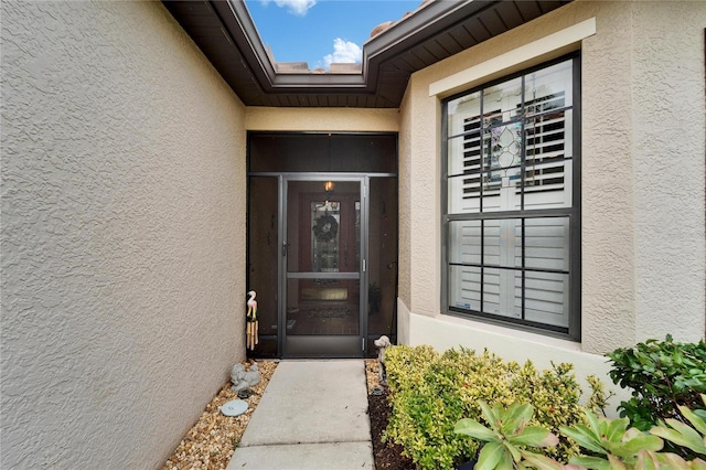 entrance to property featuring stucco siding