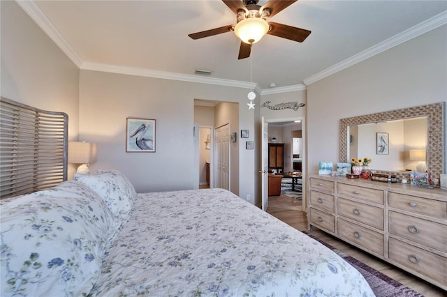 bedroom featuring dark wood finished floors, visible vents, crown molding, and ceiling fan