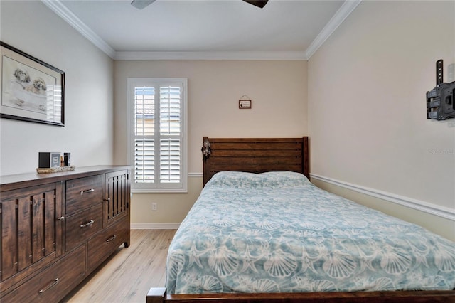 bedroom featuring light wood finished floors, crown molding, and baseboards