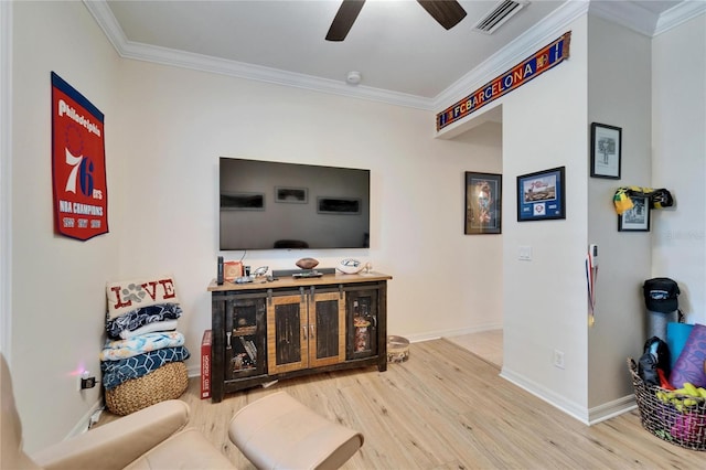 living room with wood finished floors, baseboards, visible vents, ceiling fan, and ornamental molding