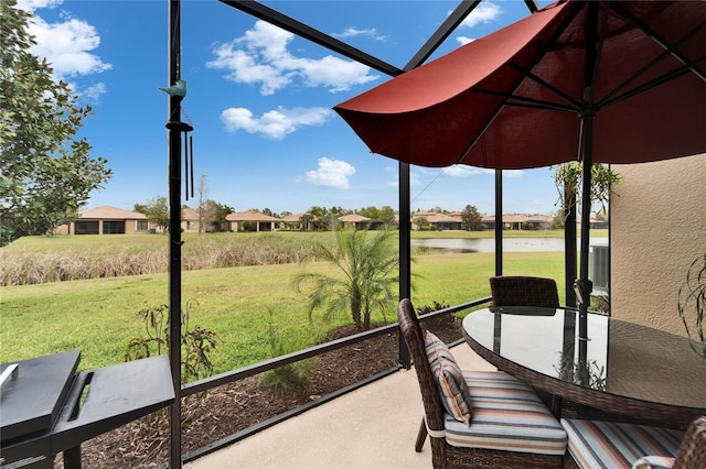 sunroom featuring a water view