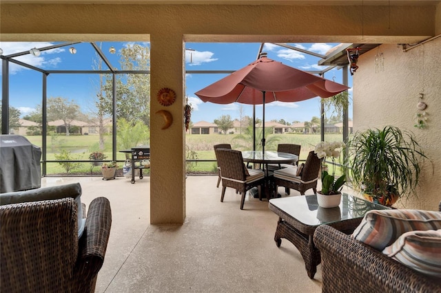 view of patio featuring area for grilling, glass enclosure, and outdoor dining area