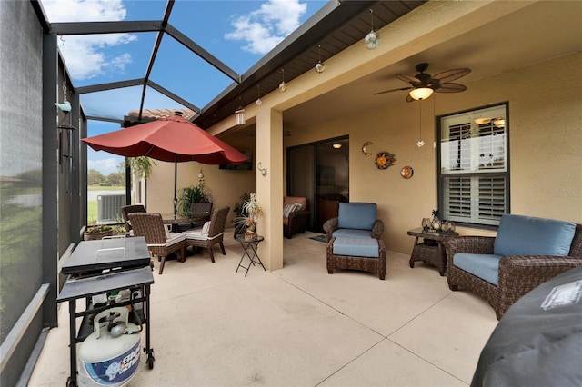 view of patio featuring an outdoor living space, glass enclosure, and ceiling fan