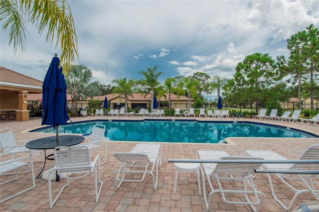 pool with a patio and fence