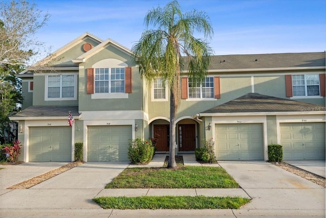 view of property with driveway, a garage, and stucco siding