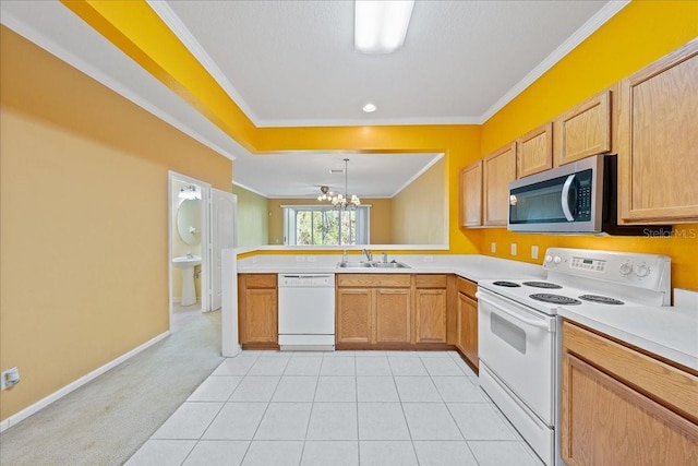 kitchen featuring a peninsula, white appliances, a sink, light countertops, and crown molding