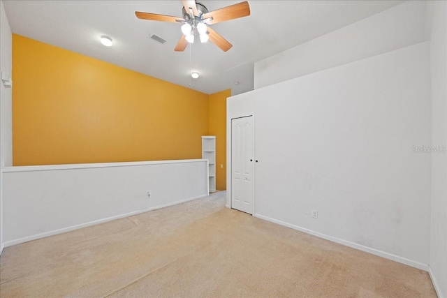 empty room with a ceiling fan, carpet, visible vents, and baseboards