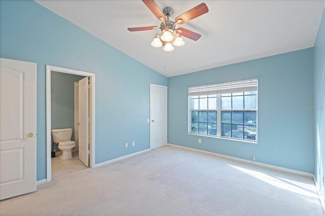 unfurnished bedroom featuring baseboards, a ceiling fan, lofted ceiling, ensuite bathroom, and carpet floors