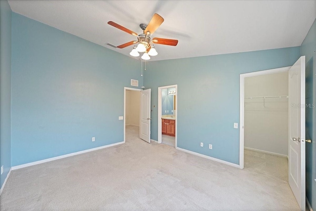 unfurnished bedroom featuring baseboards, visible vents, lofted ceiling, a spacious closet, and a closet