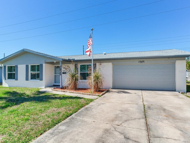 ranch-style home with a garage, concrete driveway, brick siding, and a front lawn