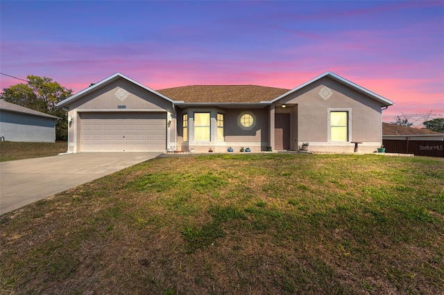 ranch-style home featuring stucco siding, a garage, concrete driveway, and a lawn