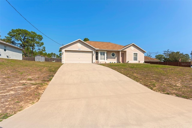 view of front facade with an attached garage, concrete driveway, a front lawn, and fence