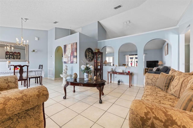 living room featuring light tile patterned flooring, visible vents, and vaulted ceiling