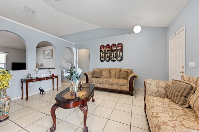 living area featuring lofted ceiling, light tile patterned floors, visible vents, and a textured ceiling