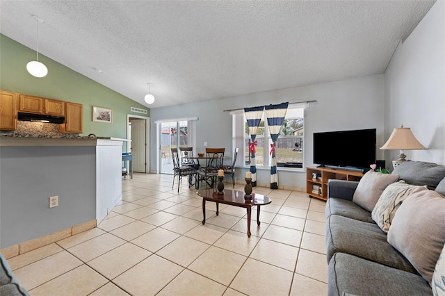 living area featuring vaulted ceiling, light tile patterned floors, and a textured ceiling