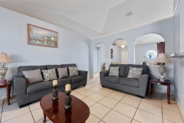 living room featuring arched walkways, visible vents, light tile patterned floors, and vaulted ceiling