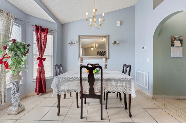 dining area with lofted ceiling, arched walkways, visible vents, and a chandelier