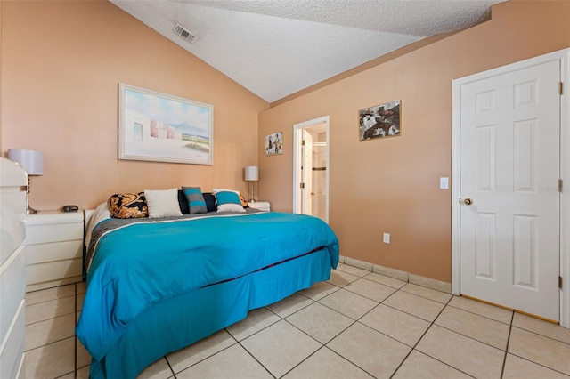 bedroom with visible vents, a textured ceiling, light tile patterned flooring, and vaulted ceiling