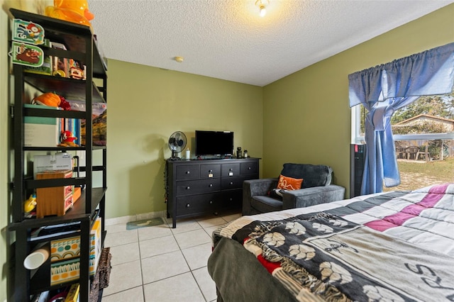 bedroom featuring baseboards, a textured ceiling, and tile patterned flooring