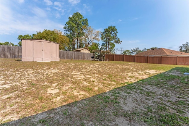 view of yard featuring an outbuilding, a storage shed, and a fenced backyard