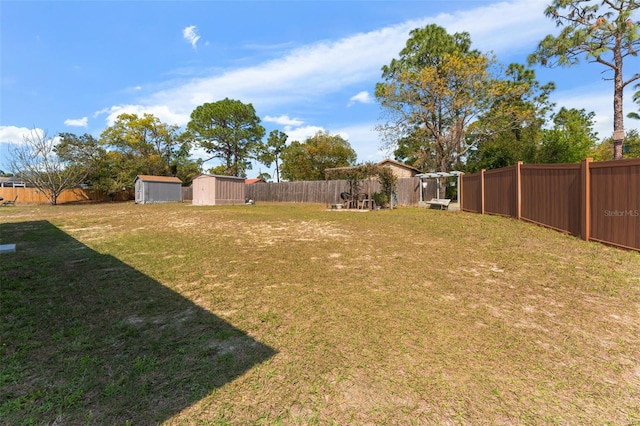 view of yard with a storage shed, a fenced backyard, and an outdoor structure