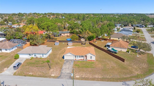 drone / aerial view with a wooded view and a residential view