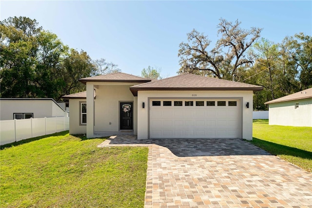 view of front facade with a garage, decorative driveway, a front lawn, and stucco siding