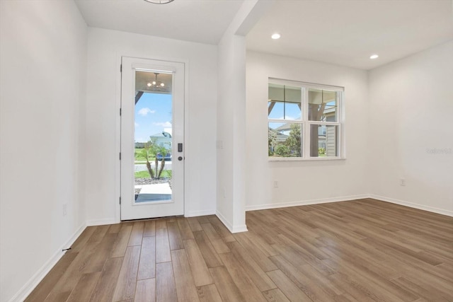 doorway featuring recessed lighting, baseboards, and wood finished floors