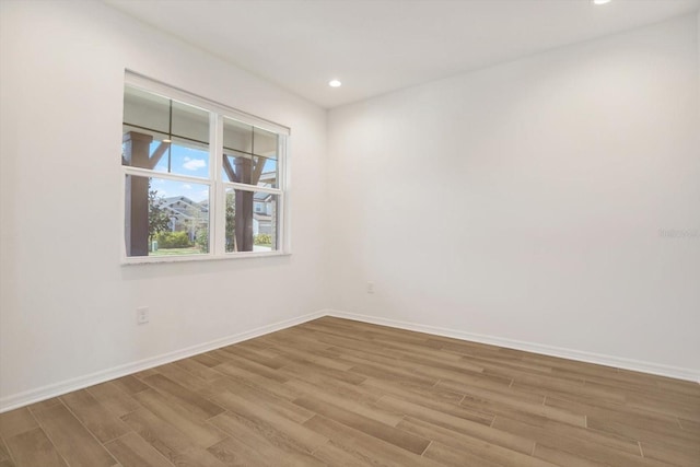 spare room with recessed lighting, baseboards, and wood finished floors