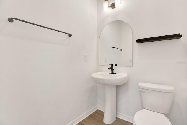 bathroom featuring baseboards, toilet, and wood finished floors