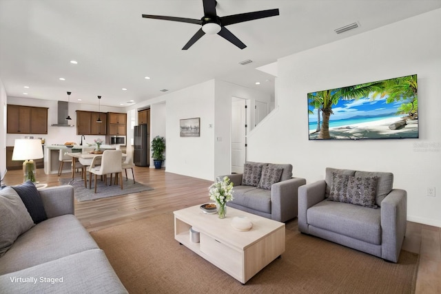 living area featuring a ceiling fan, recessed lighting, light wood-style floors, and visible vents