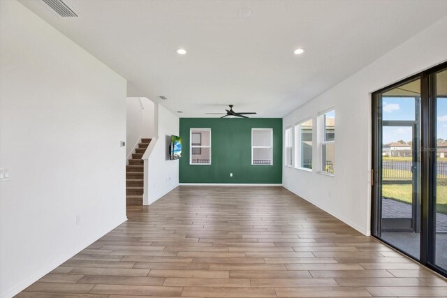 unfurnished room with recessed lighting, stairway, wood finished floors, and ceiling fan