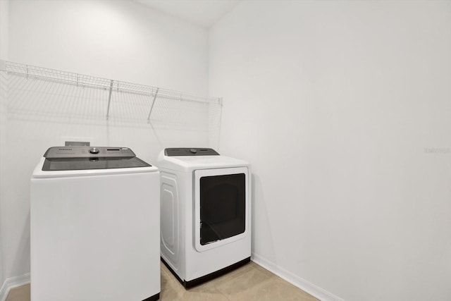 laundry room with baseboards, laundry area, and washer and clothes dryer