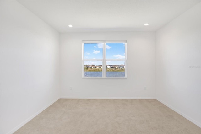 spare room featuring recessed lighting, baseboards, and light colored carpet