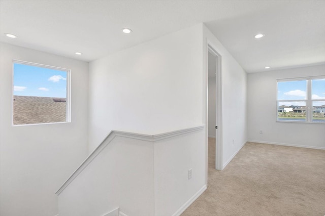 hall featuring recessed lighting, baseboards, and light carpet