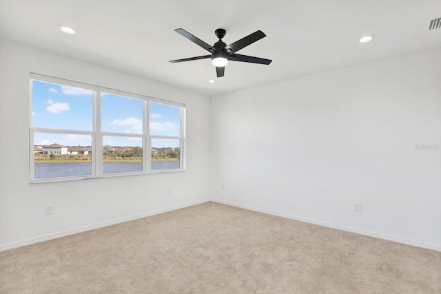 spare room featuring recessed lighting, baseboards, and light carpet