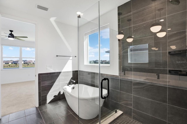 full bathroom with tile patterned floors, visible vents, tile walls, a shower stall, and a freestanding bath