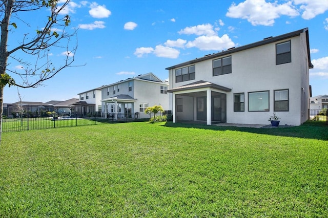 rear view of property with stucco siding, a fenced backyard, a yard, a residential view, and a sunroom