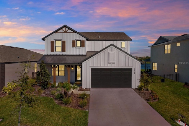 modern farmhouse featuring board and batten siding, fence, concrete driveway, a front yard, and an attached garage