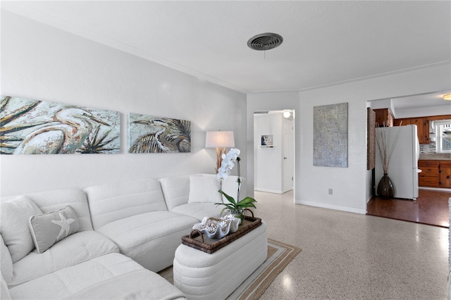 living area with baseboards, visible vents, and speckled floor